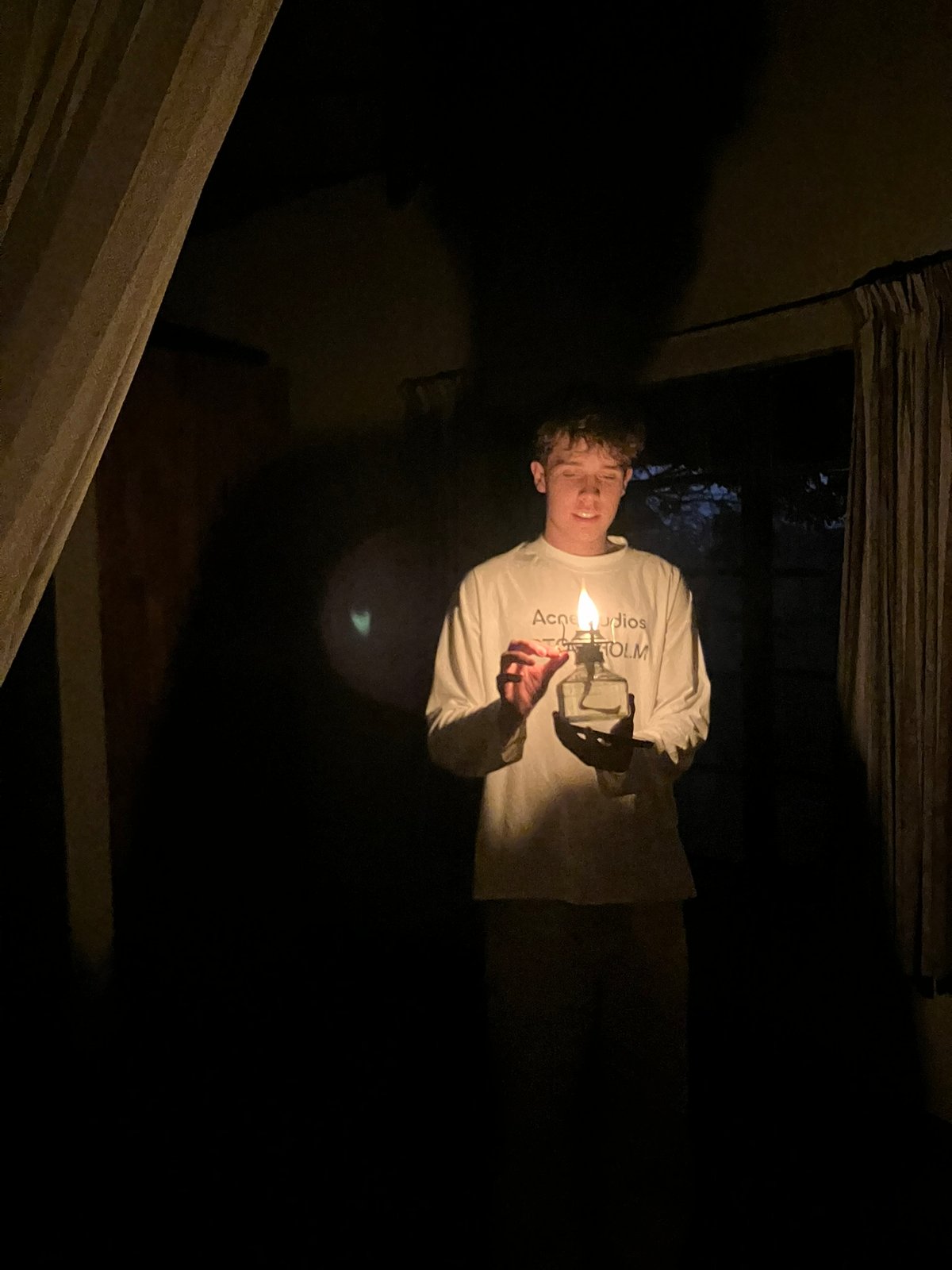 Joris hält im Dunkeln eine kleine Öllampe, ihr Licht beleuchtet sein Gesicht