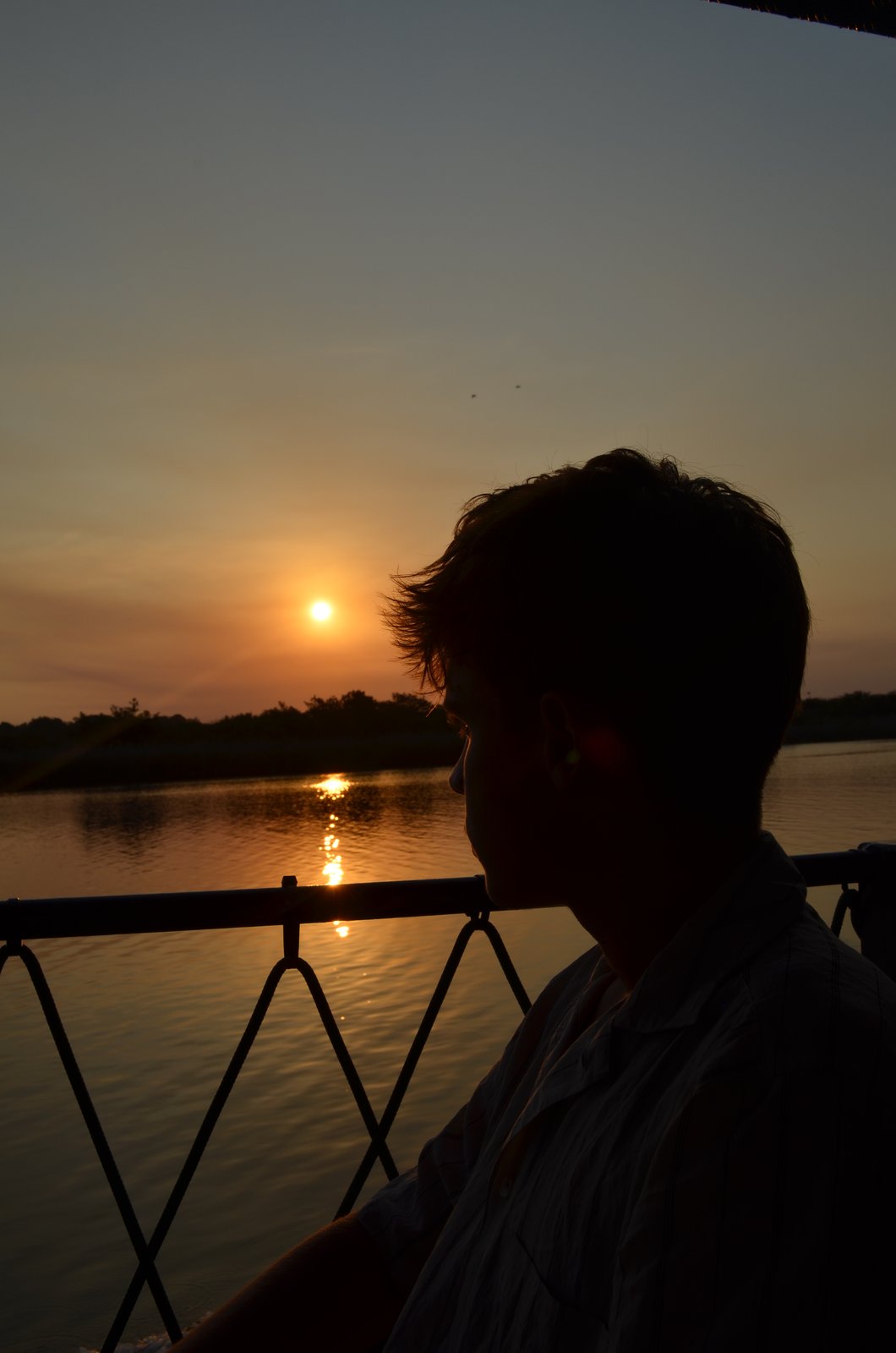 Joris im Profil vor einem Sonnenuntergang über dem Wasser